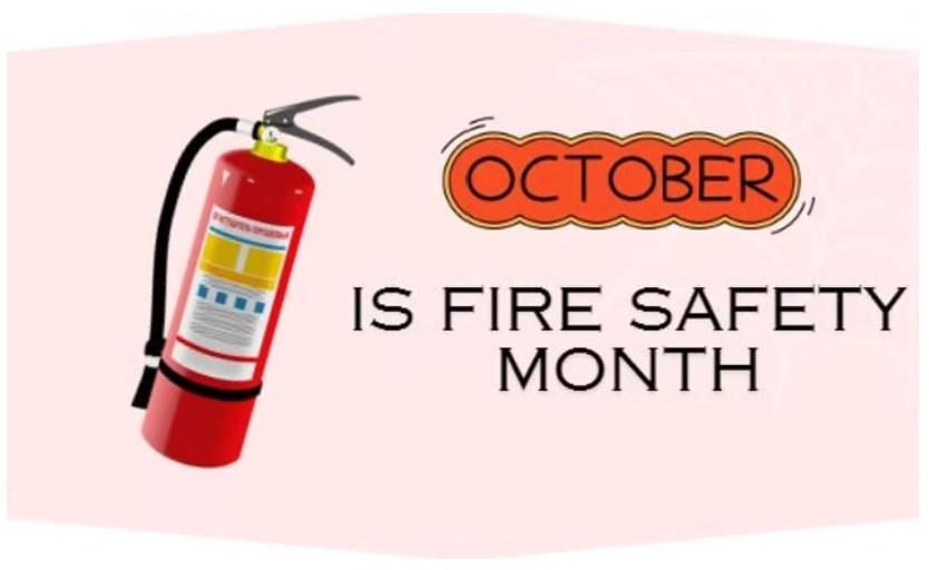 A graphic on a light pink background featuring an illustration of a red fire extinguisher on the left side. To the right, the text reads "OCTOBER IS FIRE SAFETY MONTH," with "OCTOBER" contained within a decorative orange and brown bubble.